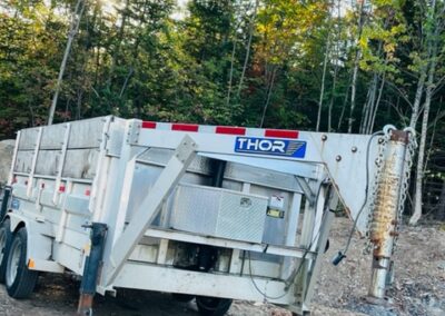 Trailer parked in a wooded area.